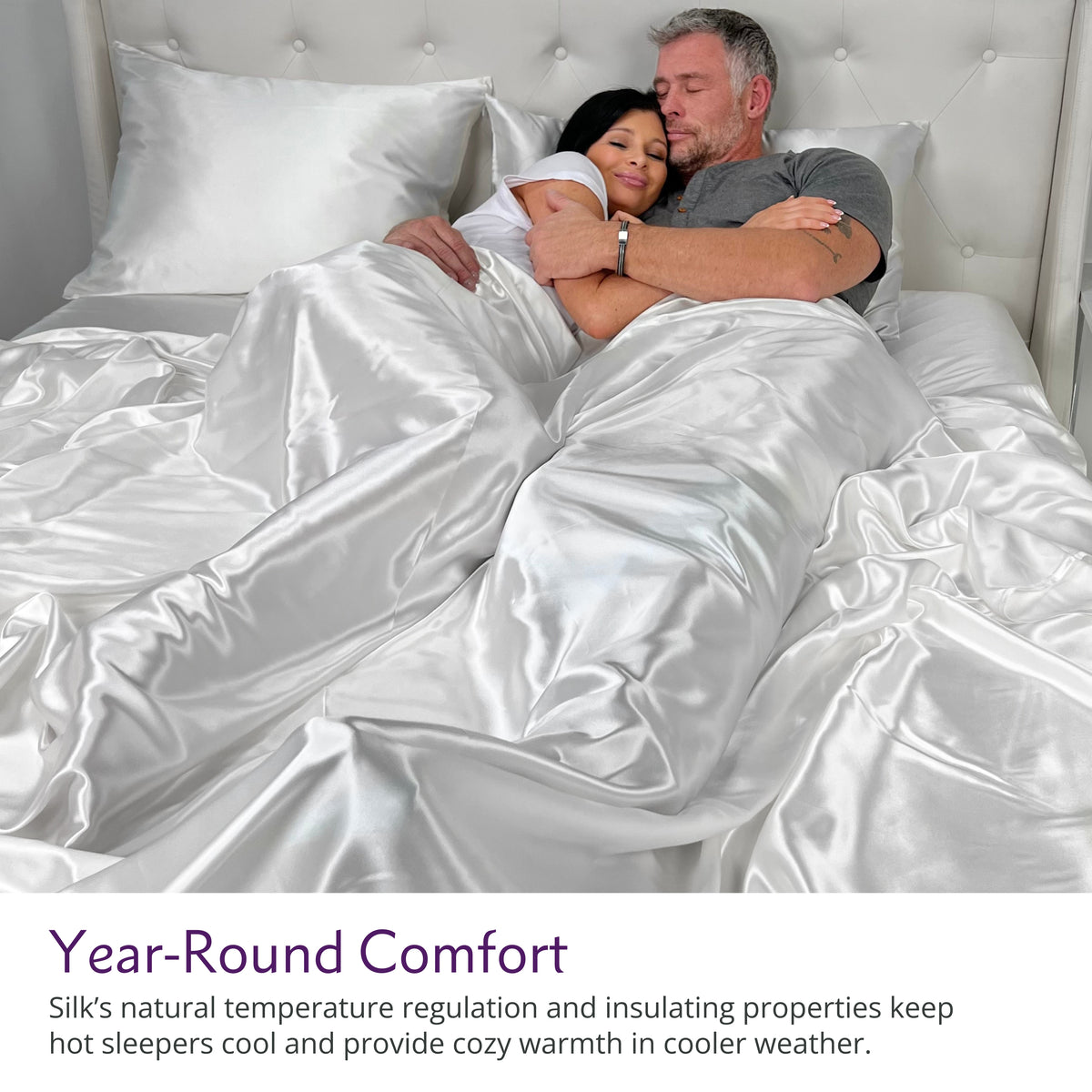 Couple cuddling on a bed with luxurious white silk sheets, enjoying comfort and elegance