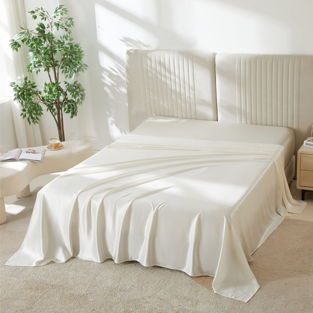 White silk flat sheet draped over a neatly made bed in a bright, modern bedroom