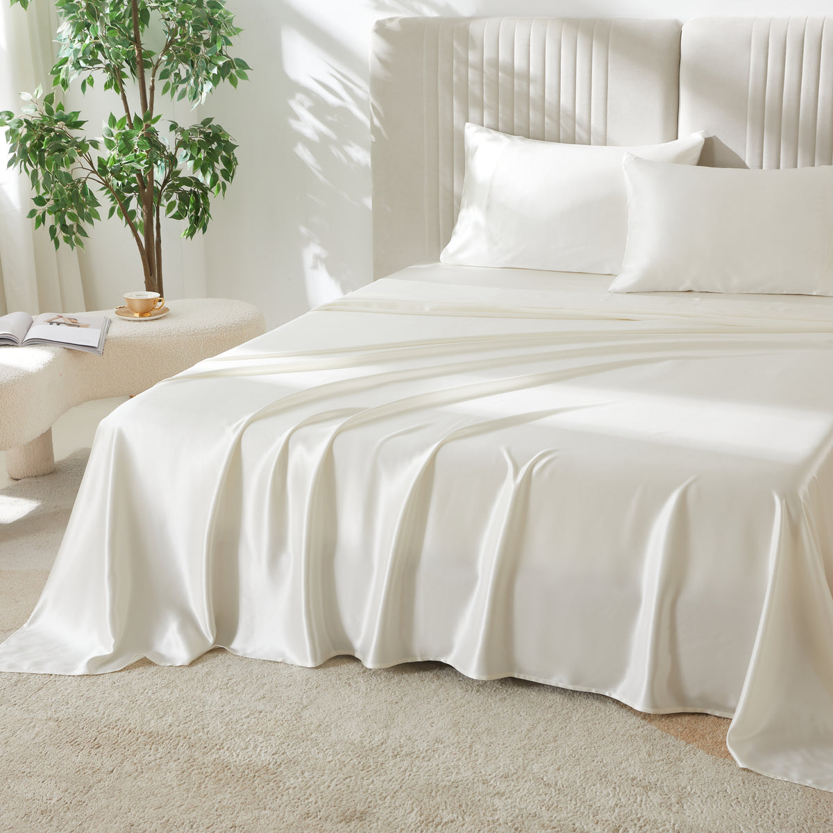Ivory silk flat sheet draped over a neatly made bed in a bright, modern bedroom