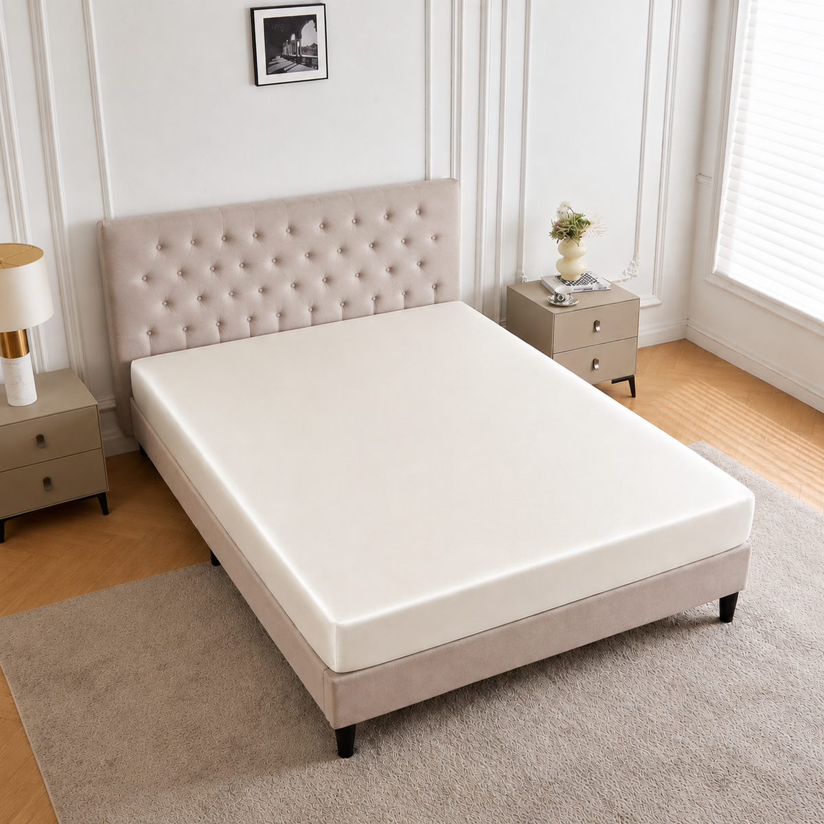 A neatly made bed with a tufted headboard, dressed in a 30 Momme Silk Fitted Sheet, brightens the minimal bedroom.