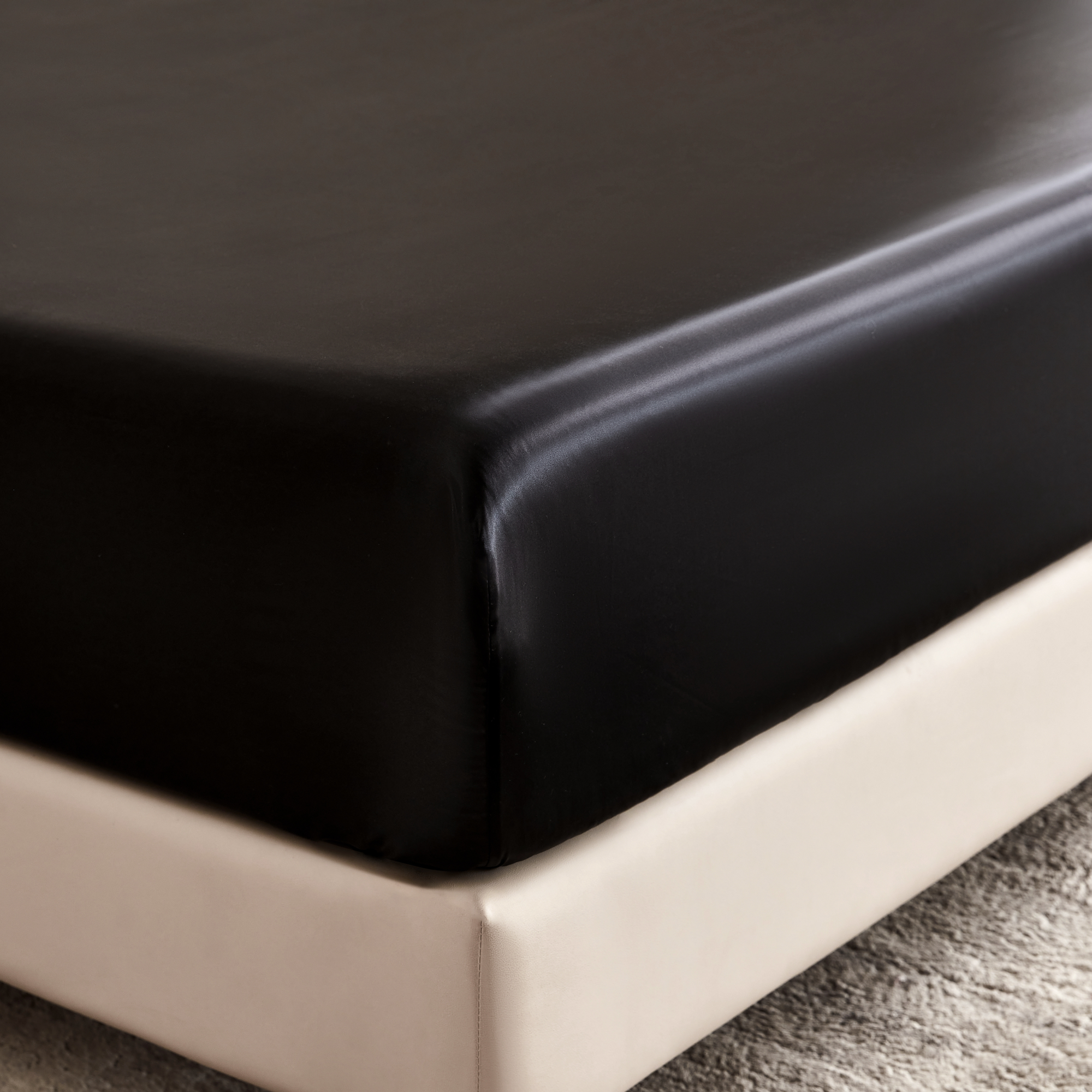 Black fitted sheet on a bed in a bedroom setting