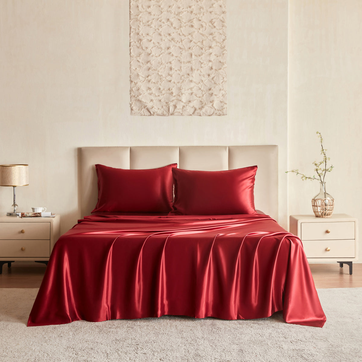 Red silk bedding set on a bed in a bedroom setting.