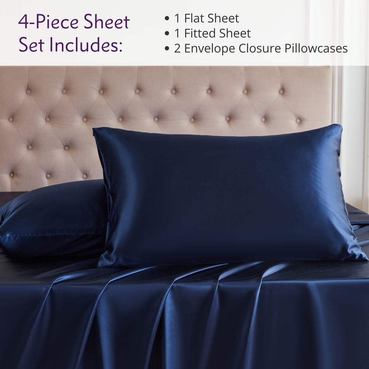 Navy blue silk sheet set on a bed with a tufted headboard.