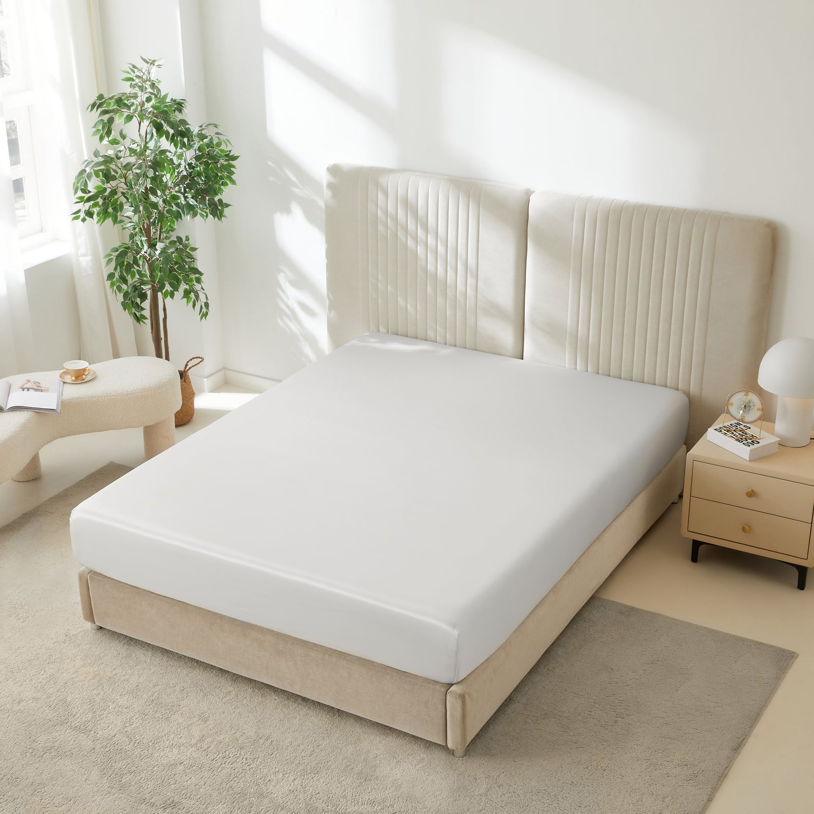 22 momme silk fitted sheet in White on bed with upholstered headboard in a cozy bedroom setting