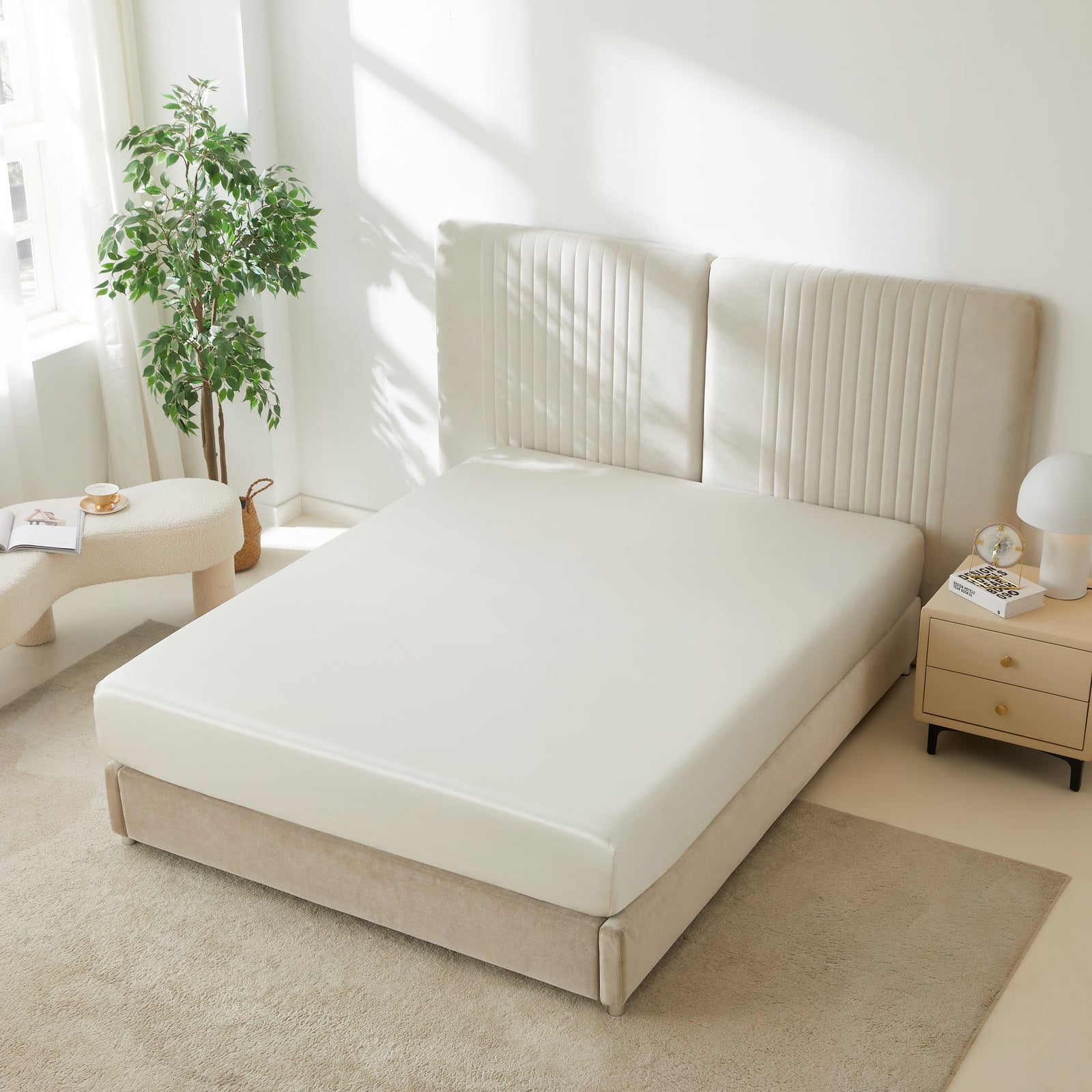 22 momme silk fitted sheet in Ivory on bed with upholstered headboard in a cozy bedroom setting