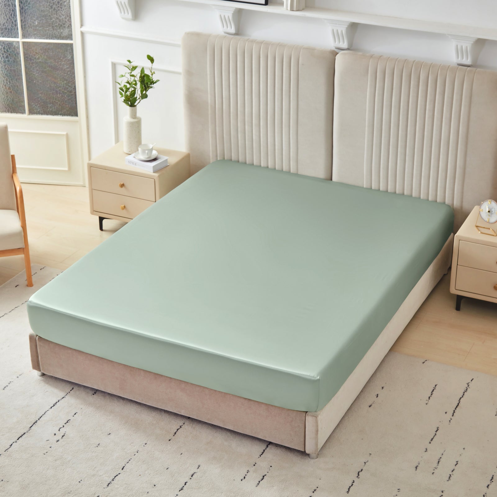 22 momme silk fitted sheet in Sage on bed with upholstered headboard in a cozy bedroom setting