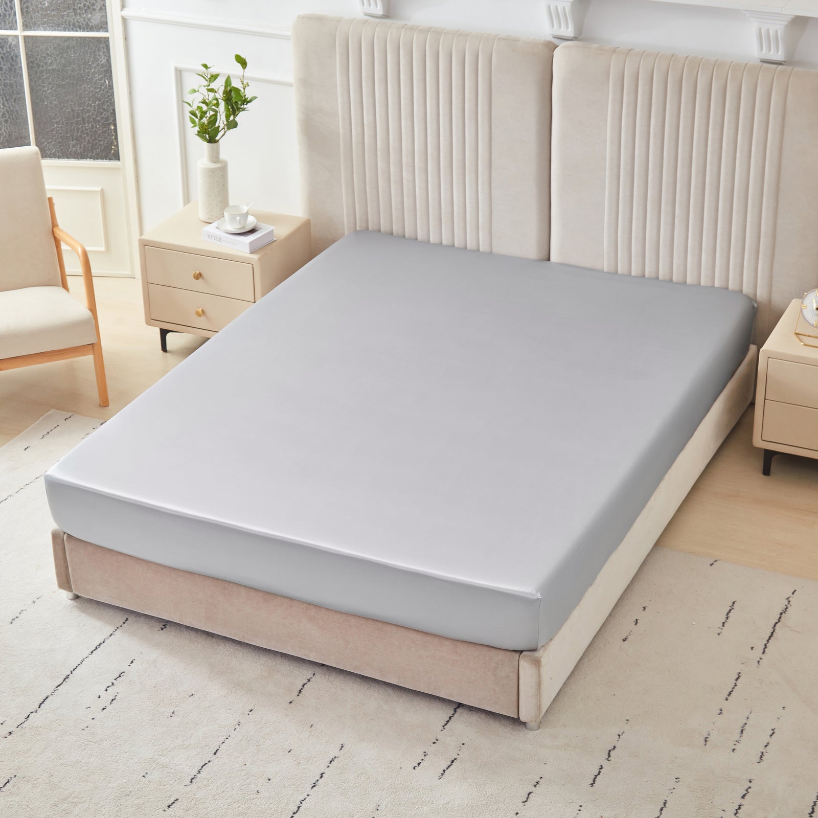 22 momme silk fitted sheet in Gunmetal on bed with upholstered headboard in a cozy bedroom setting