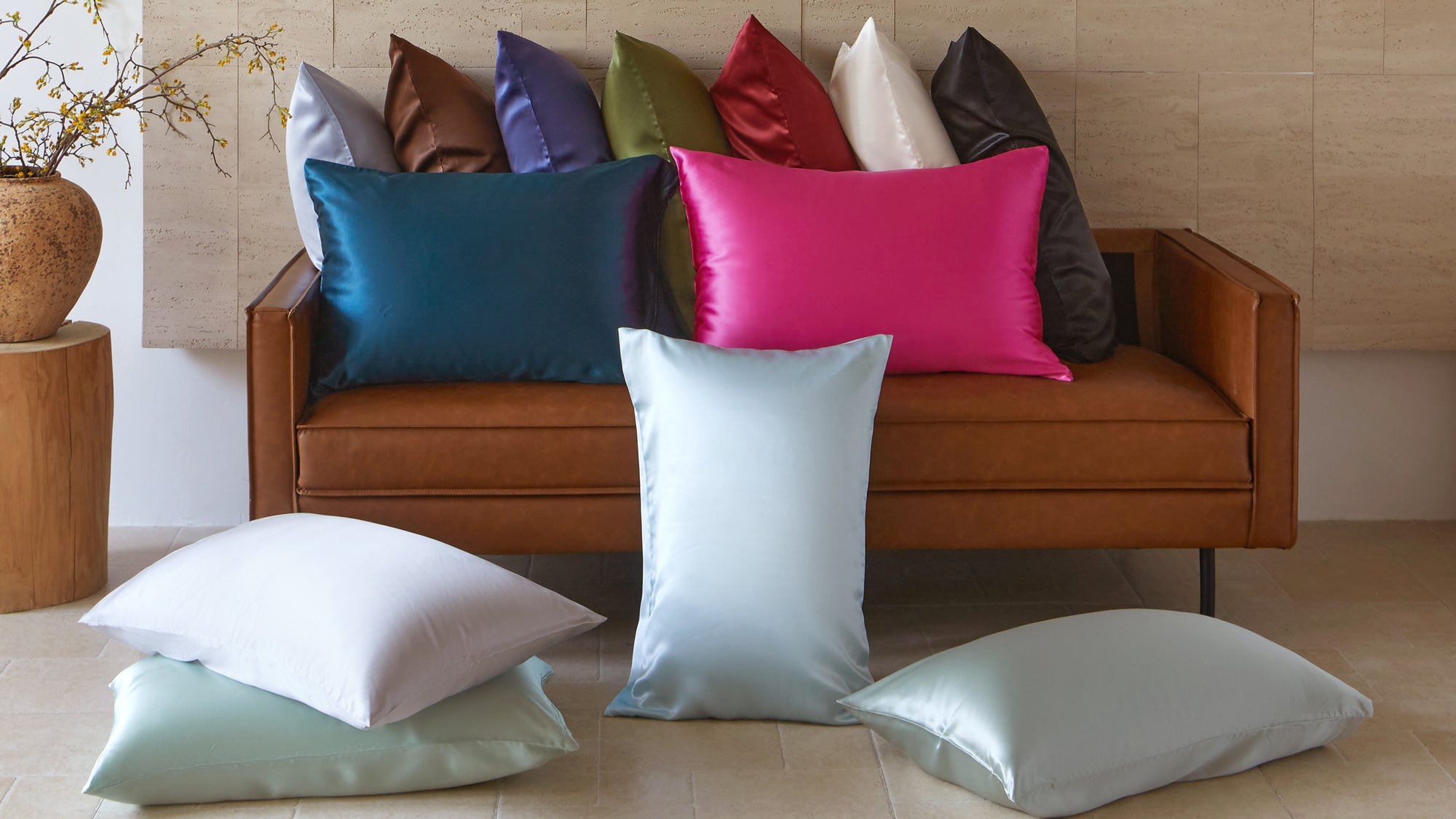 Mulberry Park Silks pillowcases in multiple colors including teal, pink, ivory, silver, and green displayed on sofa — 100% pure mulberry silk for hair and skin health.